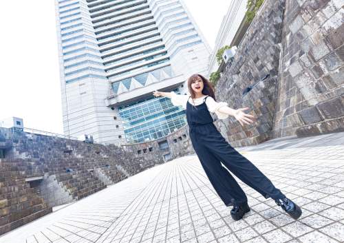 広角レンズで撮った女性とランドマークタワーの写真